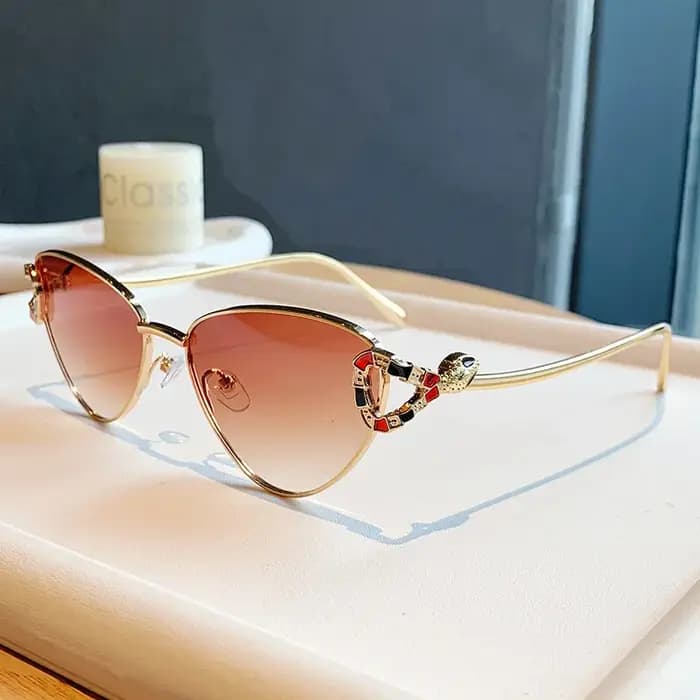 Lunettes de soleil œil de chat dorées tendance 2026 avec ornement tête de serpent