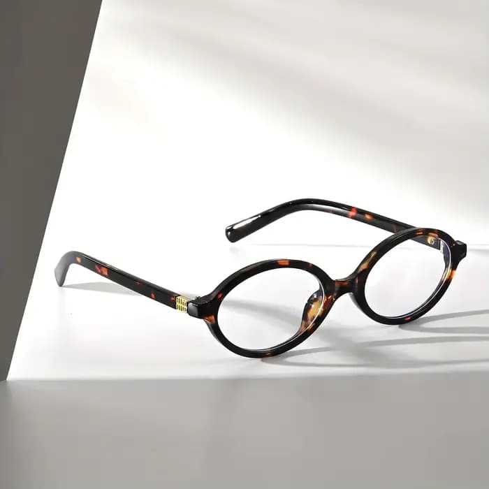 Une paire de lunettes PC ovales rétro pour hommes et femmes, conçues pour les visages fins, polyvalentes pour diverses scènes intérieures.